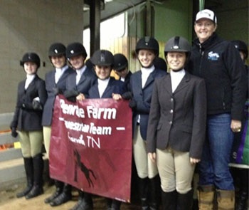 Row of youth equestrians preparing to walk into an arena with their coach